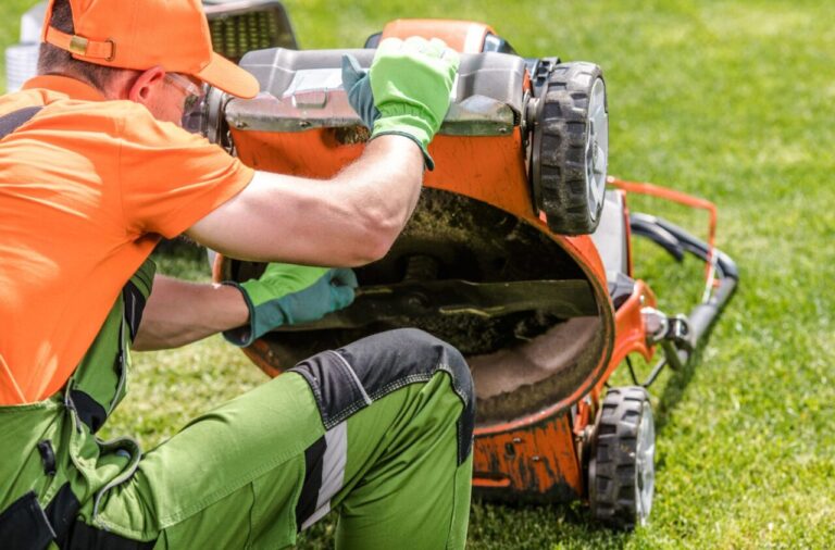 Personne vérifiant une tondeuse à gazon qui ne démarre pas dans un jardin